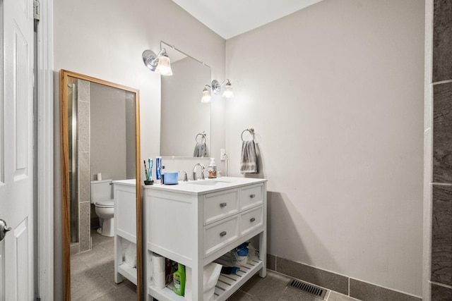 bathroom with vanity, toilet, and tile patterned flooring