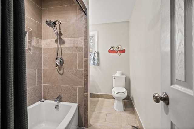 bathroom with tiled shower / bath combo and toilet