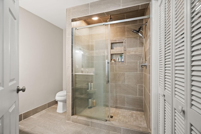 bathroom with a shower with shower door and toilet