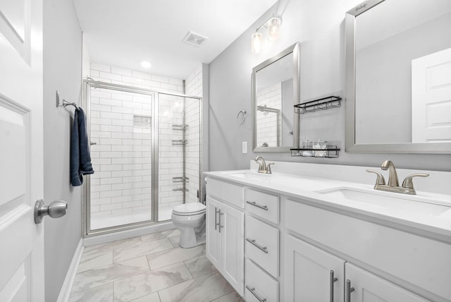 bathroom with vanity, a shower with shower door, and toilet