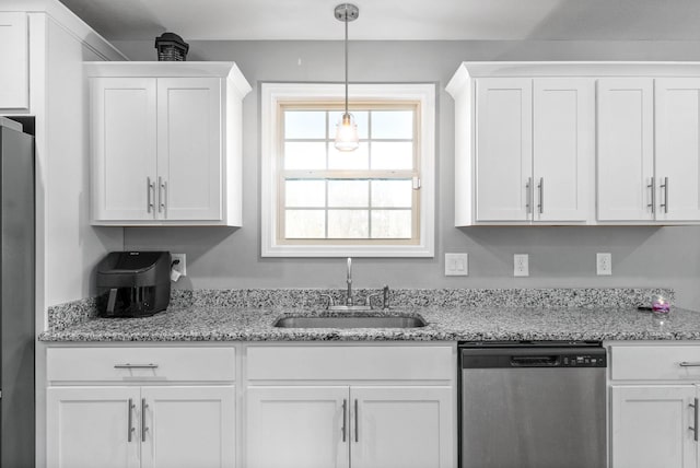 kitchen with sink, white cabinetry, light stone counters, hanging light fixtures, and stainless steel appliances