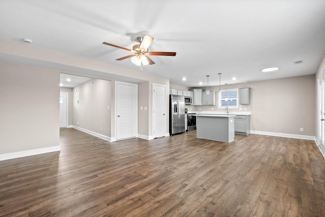 kitchen with decorative light fixtures, stainless steel appliances, dark hardwood / wood-style floors, and a kitchen island