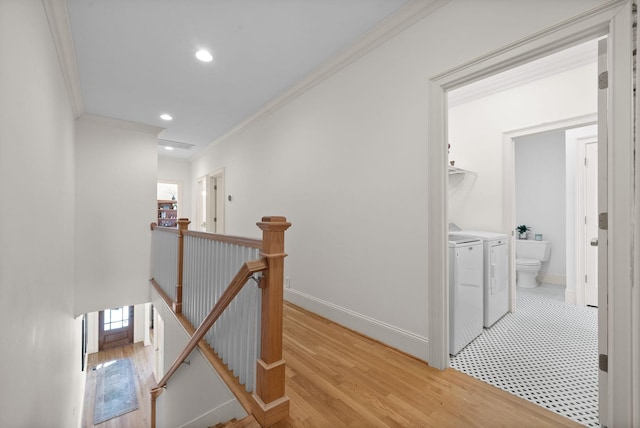 hallway with separate washer and dryer, crown molding, and light hardwood / wood-style floors