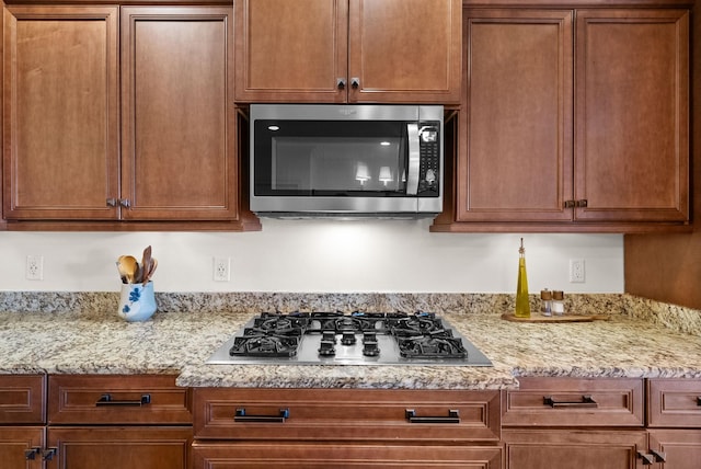 kitchen featuring light stone countertops and stainless steel appliances