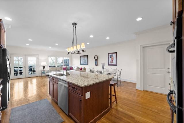 kitchen featuring a breakfast bar, sink, crown molding, a center island with sink, and stainless steel dishwasher