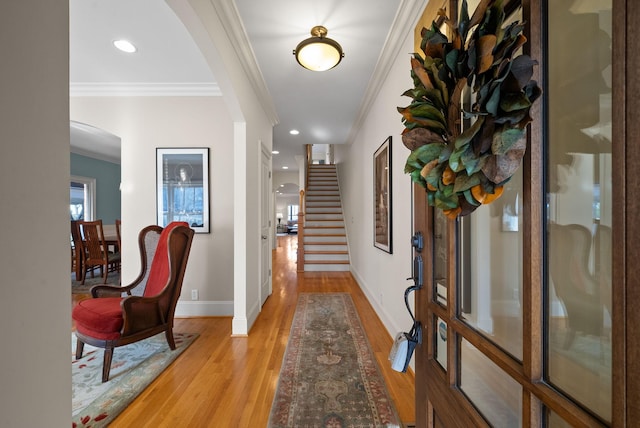 entrance foyer with crown molding and light hardwood / wood-style flooring