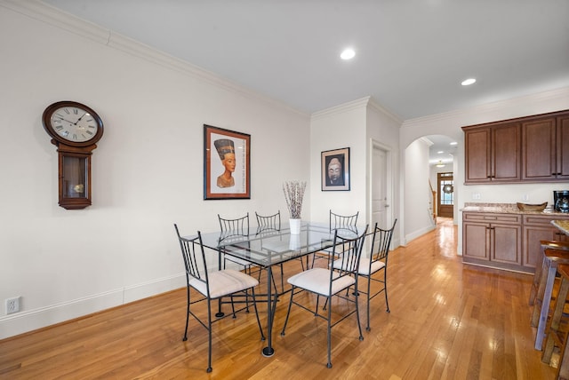 dining room with crown molding and light hardwood / wood-style floors