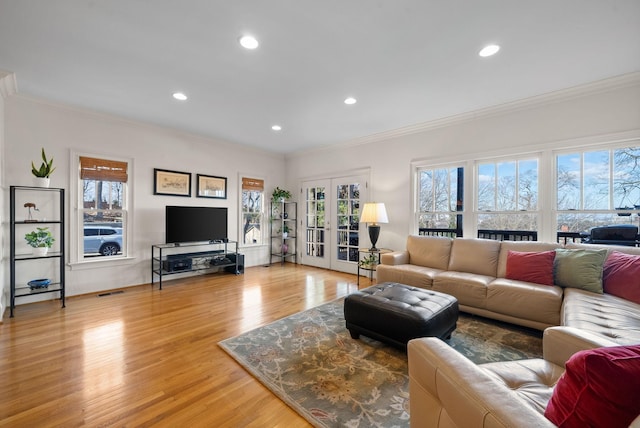 living room with french doors, crown molding, and light hardwood / wood-style flooring