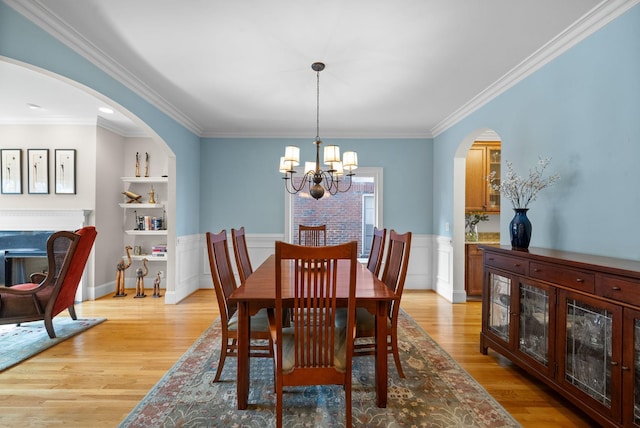 dining room featuring crown molding, a notable chandelier, and light hardwood / wood-style flooring