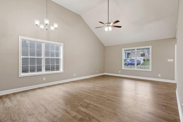 unfurnished living room with wood-type flooring, ceiling fan with notable chandelier, and high vaulted ceiling