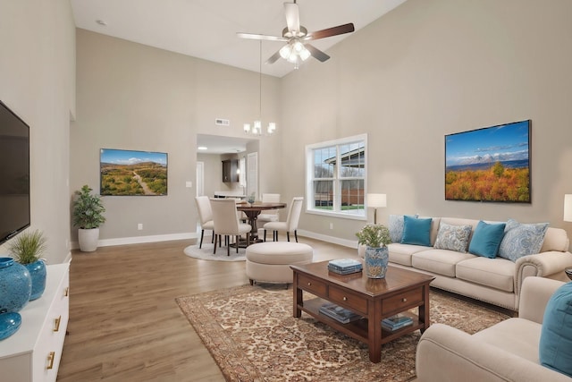 living room with ceiling fan, hardwood / wood-style floors, and high vaulted ceiling