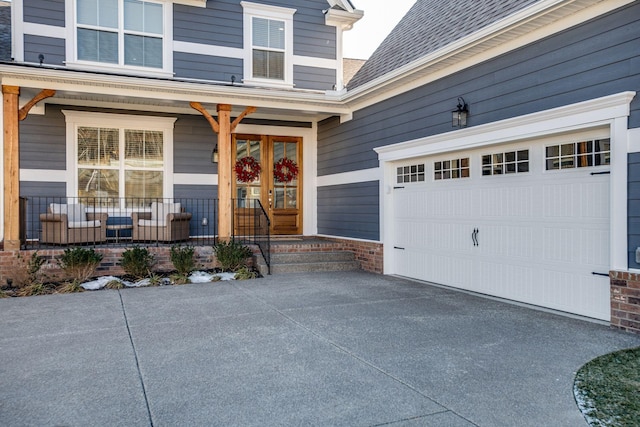 entrance to property featuring a garage and covered porch