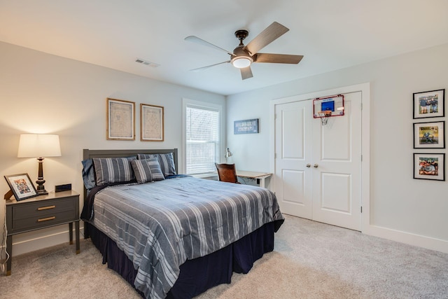 bedroom featuring light colored carpet, a closet, and ceiling fan