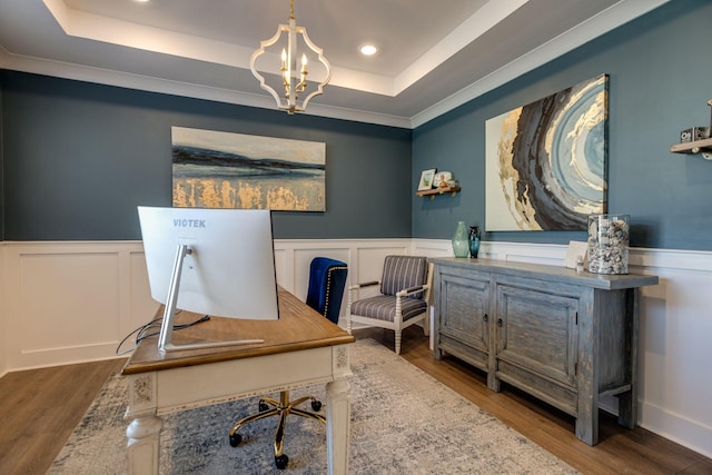 office with a raised ceiling, hardwood / wood-style floors, and a notable chandelier