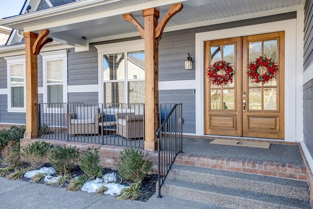 view of exterior entry featuring a porch and french doors