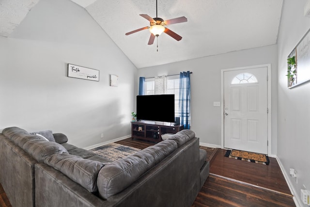 living room with dark wood-type flooring, ceiling fan, vaulted ceiling, and a textured ceiling