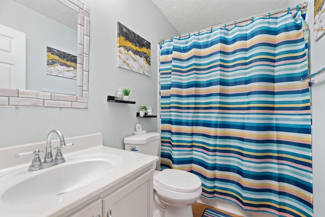 bathroom featuring vanity, toilet, and a textured ceiling