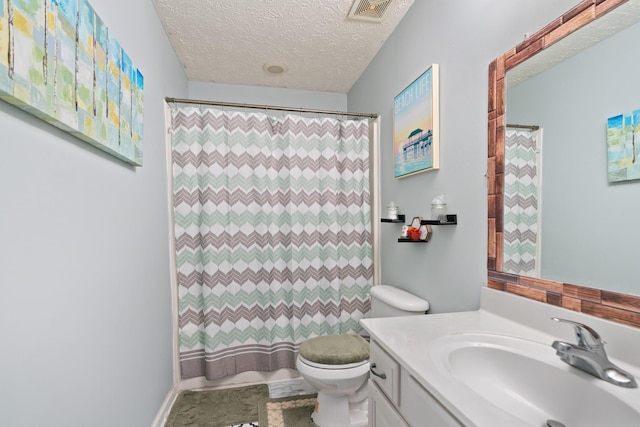 bathroom with curtained shower, toilet, and a textured ceiling