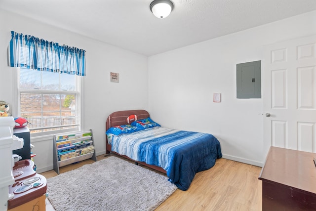 bedroom with hardwood / wood-style floors and electric panel