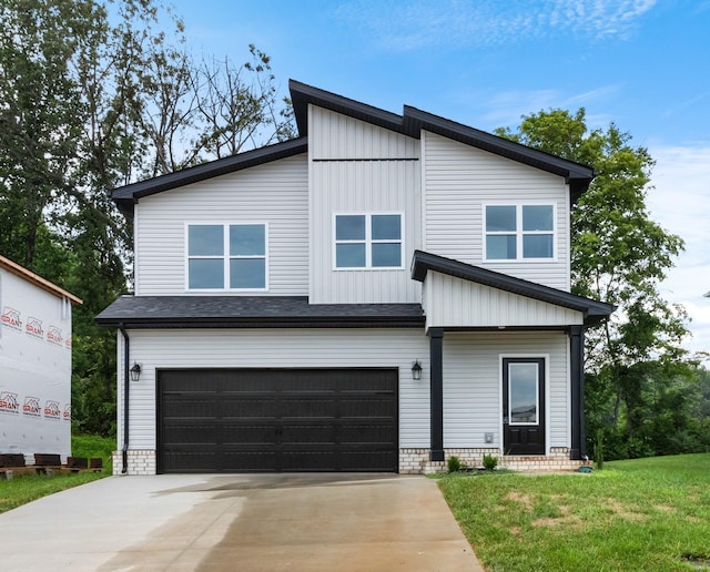 view of front of property featuring a garage and a front lawn