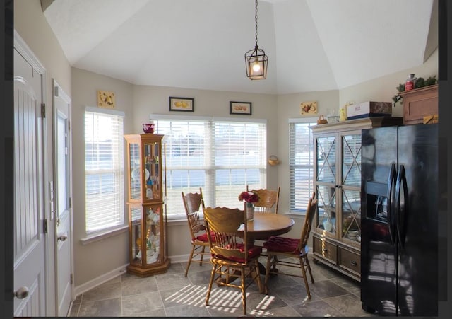 tiled dining room featuring lofted ceiling