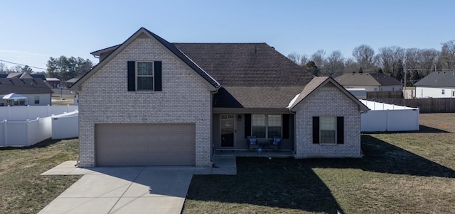 view of front of property featuring a garage, a front yard, and covered porch