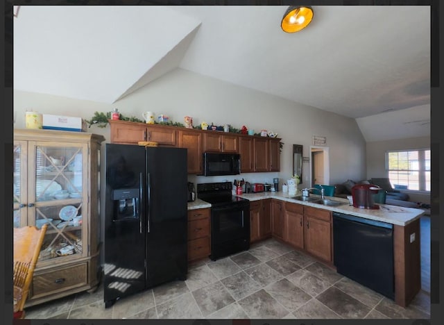 kitchen with vaulted ceiling, sink, kitchen peninsula, and black appliances