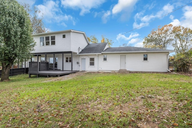 rear view of property featuring a yard and a deck