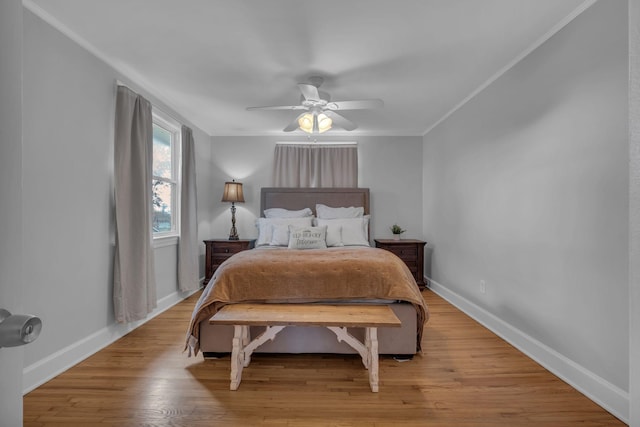 bedroom featuring ornamental molding, light hardwood / wood-style floors, and ceiling fan