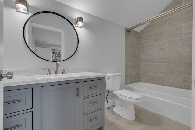 full bathroom featuring vanity, tiled shower / bath, and toilet