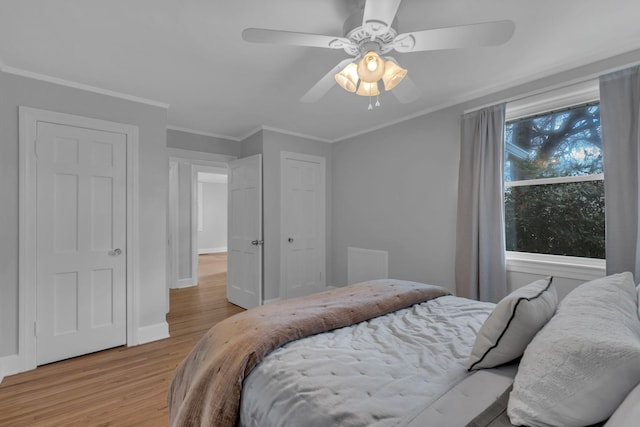 bedroom with crown molding, ceiling fan, and light hardwood / wood-style flooring