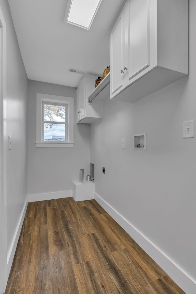 clothes washing area featuring dark hardwood / wood-style floors, cabinets, hookup for an electric dryer, and hookup for a washing machine