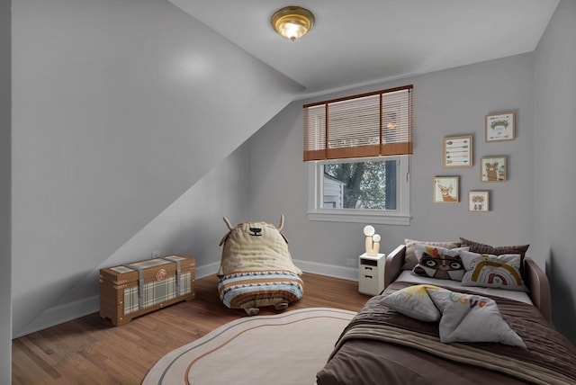 bedroom with hardwood / wood-style floors and vaulted ceiling