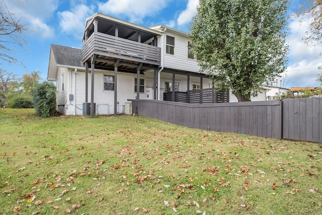 back of house with central AC unit and a yard