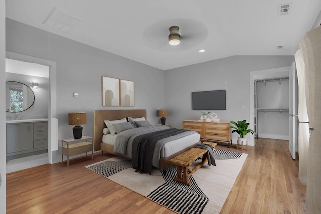 bedroom with ceiling fan, ensuite bathroom, light hardwood / wood-style floors, and a closet