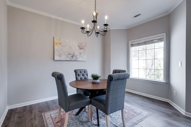 dining room featuring crown molding, dark hardwood / wood-style floors, and a chandelier