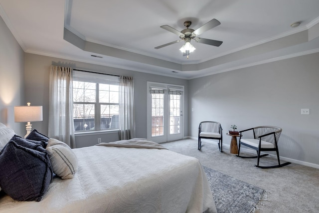 bedroom featuring ceiling fan, ornamental molding, a tray ceiling, and light carpet