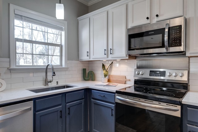 kitchen featuring blue cabinets, sink, white cabinetry, pendant lighting, and stainless steel appliances