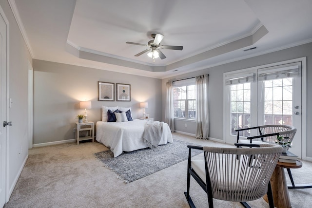 bedroom with crown molding, a tray ceiling, light colored carpet, and ceiling fan