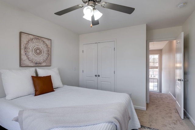 bedroom with light colored carpet, a closet, and ceiling fan