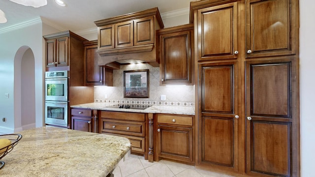 kitchen featuring crown molding, double oven, backsplash, black electric stovetop, and light stone countertops