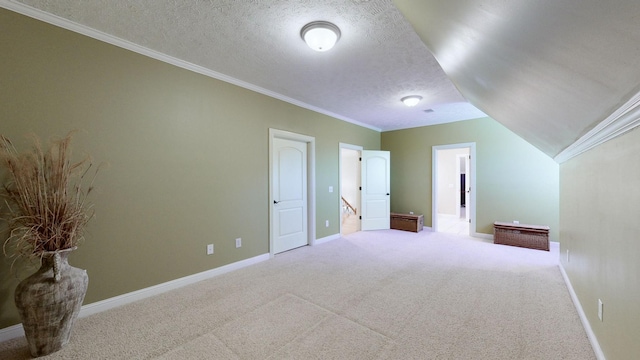 bonus room featuring lofted ceiling, light carpet, and a textured ceiling