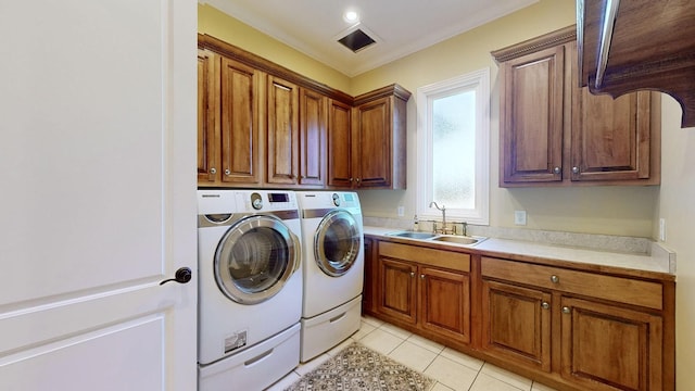 clothes washing area featuring light tile patterned flooring, sink, cabinets, ornamental molding, and washer and clothes dryer