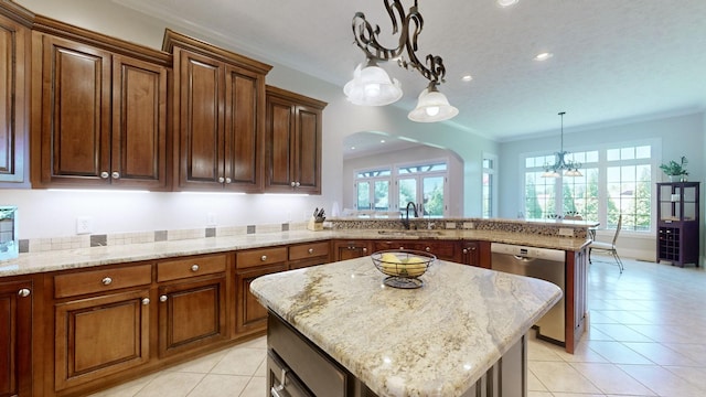 kitchen featuring pendant lighting, dishwasher, ornamental molding, a kitchen island, and kitchen peninsula