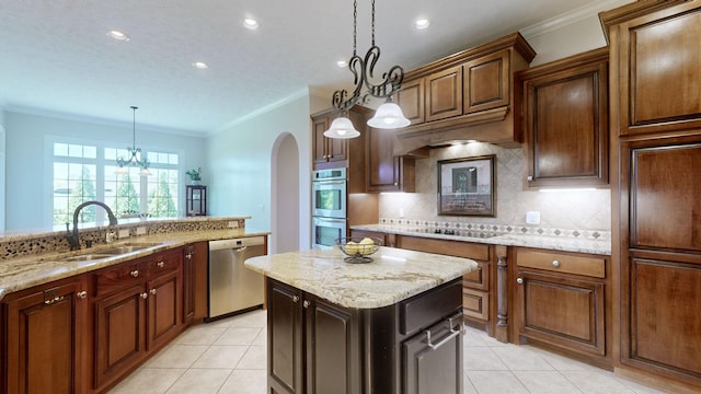 kitchen with sink, crown molding, hanging light fixtures, a kitchen island, and stainless steel appliances