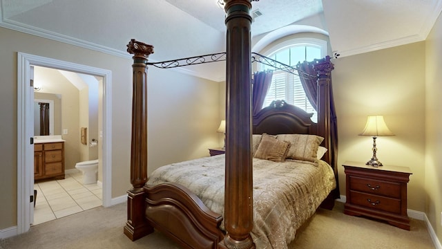 bedroom with crown molding, ensuite bathroom, and light carpet