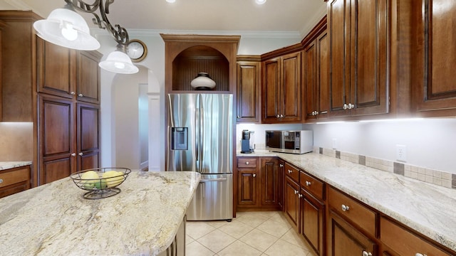 kitchen with pendant lighting, light stone counters, stainless steel appliances, and crown molding