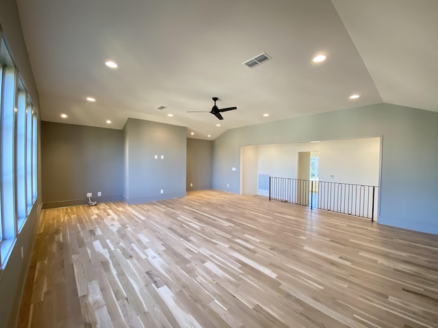 empty room with ceiling fan, vaulted ceiling, and light hardwood / wood-style flooring