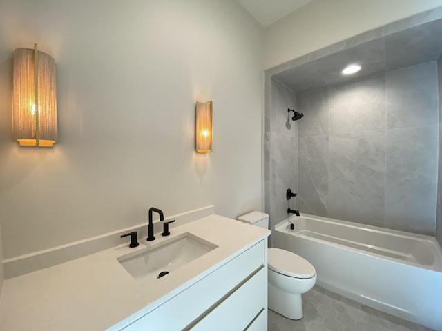 full bathroom featuring tiled shower / bath, vanity, tile patterned floors, and toilet