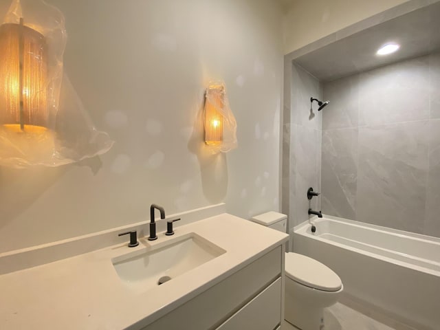 full bathroom with tiled shower / bath, vanity, and toilet